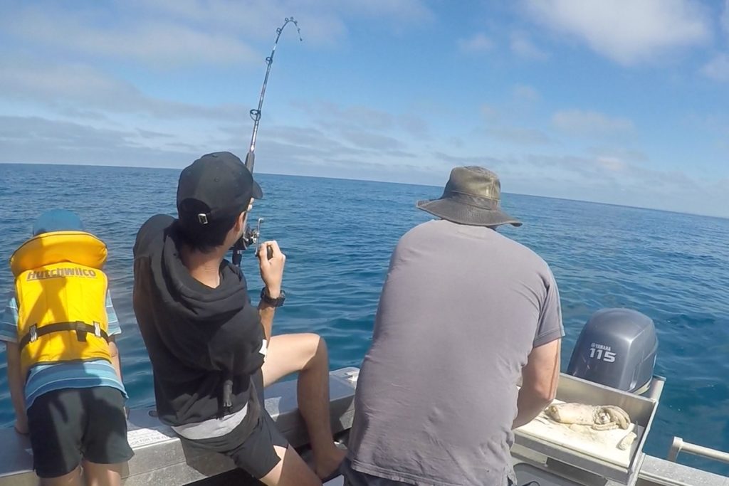 Teenager catching a fish off Patea