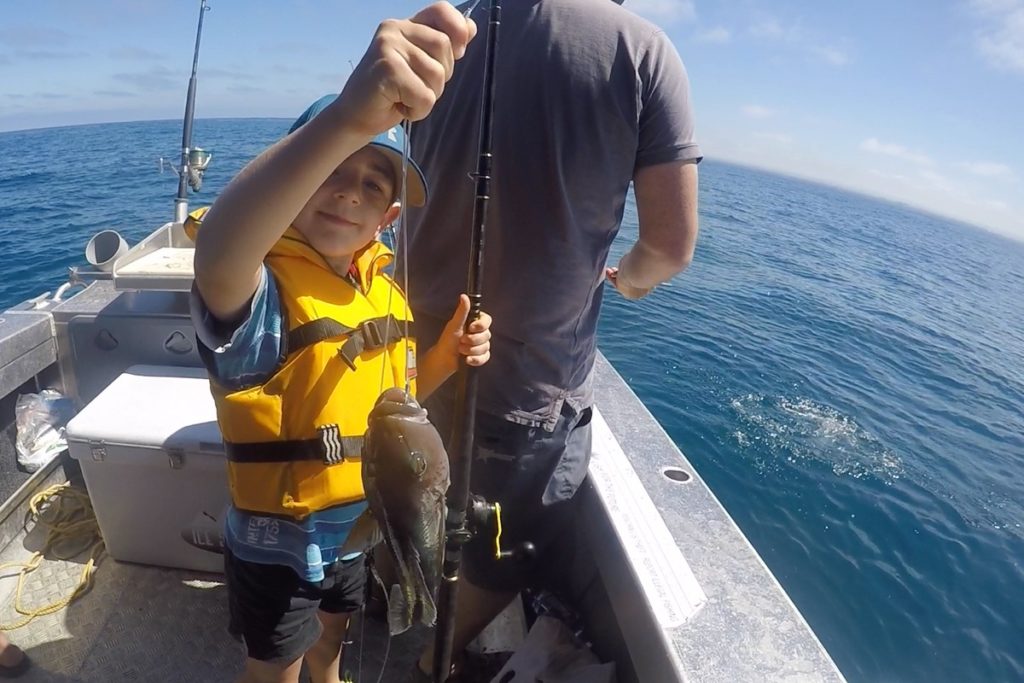 young child with blue cod at Patea